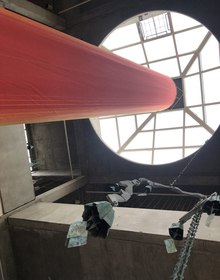 Bronze bell castings on chains under a round skylight in the foundry