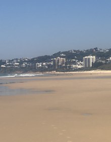 The headland and its hillside town seen along the wet sand