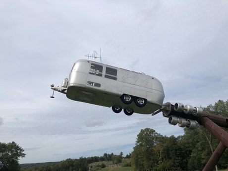 An Airstream trailer thrown into the air on a steel arm