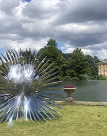 A mirrored sculpture on the lawn beside the Palm House Pond