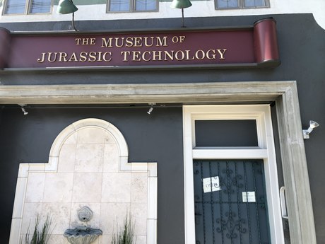 The front of the museum: its sign, a fountain in an arched niche, and the door