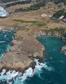Turquoise cove and rocky headland below the bluff meadow