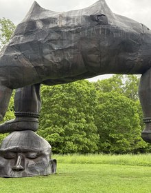 A vast arching bronze figure on the lawn
