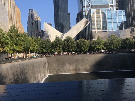 A memorial pool, the names on its parapet, the Oculus behind